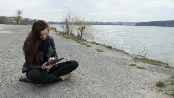 Lächelnd schöne junge Frau Sand mit einem Tablet-PC — Stockvideo