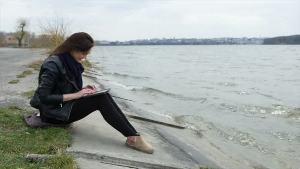 Schönes Mädchen, das am Strand am Tablet arbeitet — Stockvideo