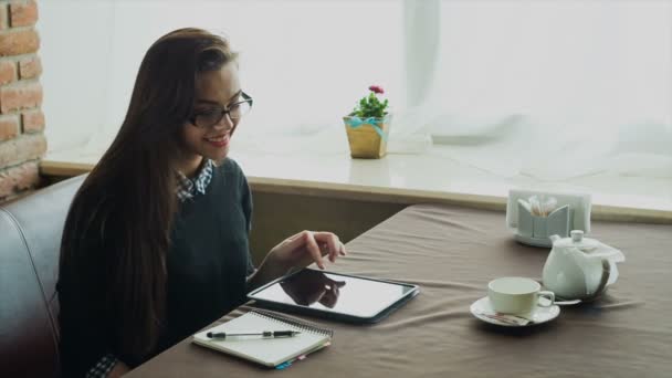 Hermosa mujer joven en la cafetería y el uso de tableta digital — Vídeo de stock