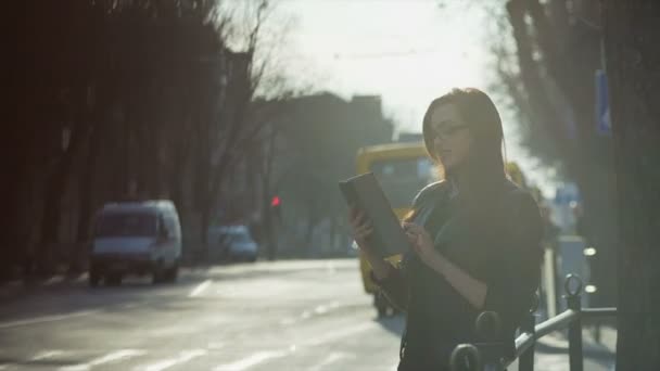 Mujer joven con una tableta en la calle pm — Vídeos de Stock
