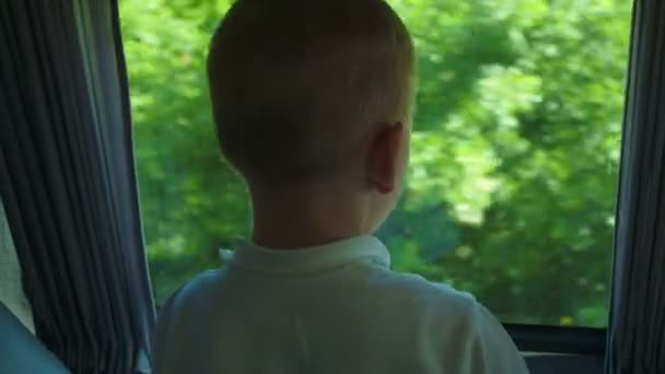 Niño mirando por la ventana abierta del autobús durante el viaje — Vídeos de Stock