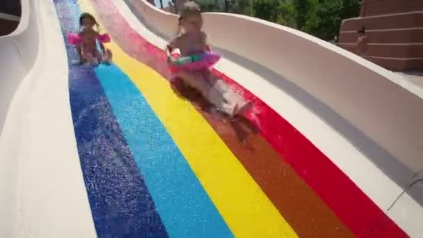 Menina bonita vai para baixo na colina em aquapark de um complexo divertido — Vídeo de Stock