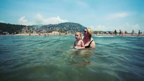 Wasser sitzende Welle wartet auf Mutter mit Kind. Rohes Videorecord. — Stockvideo