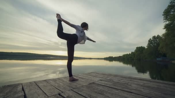 Nainen tekee joogaa rannalla — kuvapankkivideo