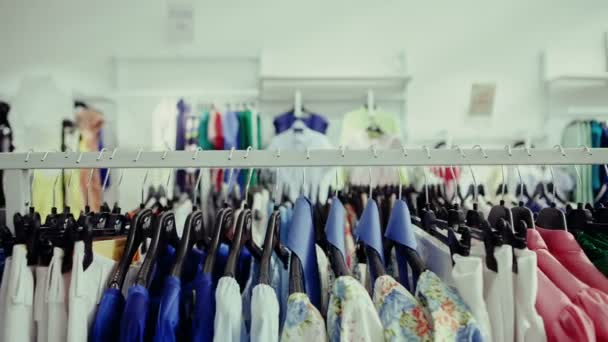 Choice of fashion clothes of different colors on hangers — Stock Video