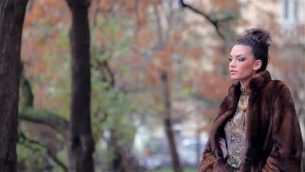 性感的年轻女性在秋天公园散步 — 图库视频影像