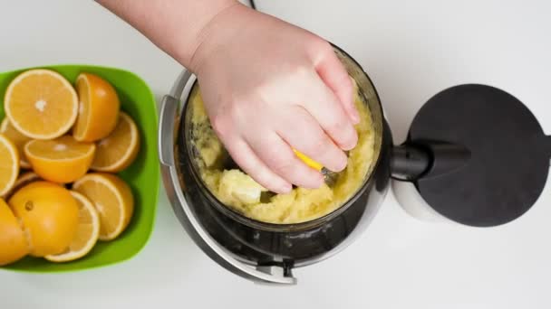 Womans hand making orange juice using a juicer — Stock video