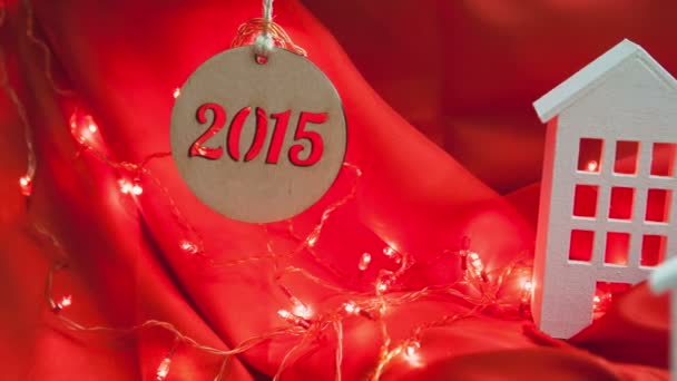 Yeni yıl 2015. Kırmızı bir arka plan üzerinde dekoratif kompozisyon evleri. — Stok video