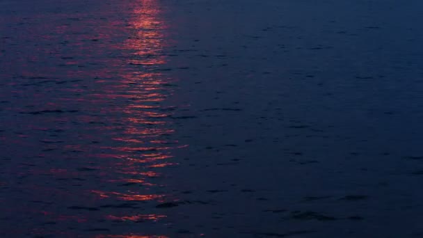 Puesta de sol reflejándose en la superficie del agua del lago — Vídeos de Stock