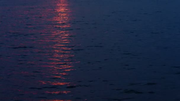 Pôr do sol refletindo sobre a superfície da água do lago — Vídeo de Stock