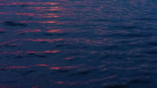Ljusvågor på vattnet på natten med reflexer från solljus — Stockvideo