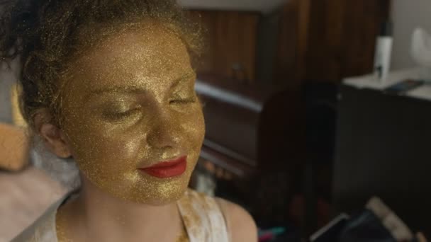 Woman with art fashion make up on face. Gold skin type make up — ストック動画