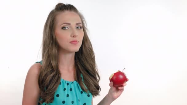 Mujer joven comiendo la manzana roja. Aislado sobre blanco. Grabación de vídeo en bruto 4K . — Vídeo de stock