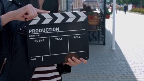 Hermosa chica con un clapperboard en las calles — Vídeo de stock