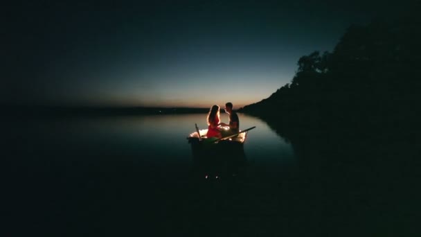 Романтическое путешествие двух влюбленных на лодке ночью — стоковое видео