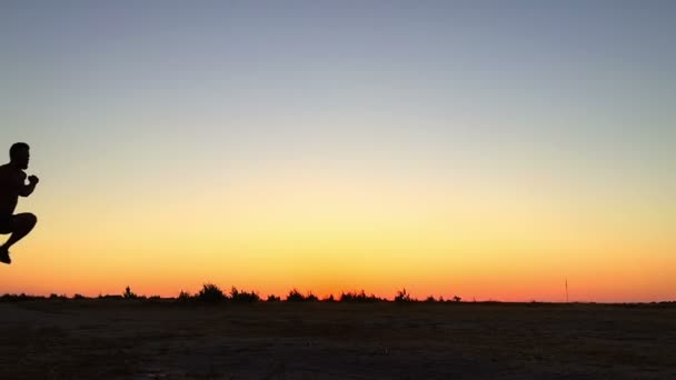 Young man running at sunset — Stock Video