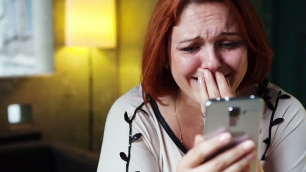 Łzy radości na twarzy kobiety, która używa pewien smartphone. — Wideo stockowe