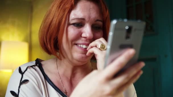 Mujer adulta escribiendo mensaje de correo electrónico en el teléfono inteligente y feliz expresión facial y maravilla . — Vídeos de Stock