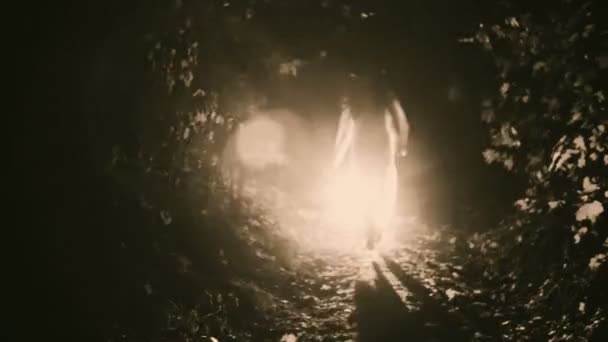 Una chica en un vestido blanco corriendo bosque nocturno — Vídeo de stock