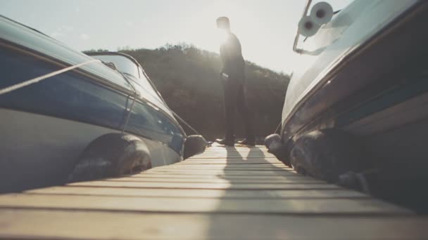 Young businessman goes past the front light boat — Stock Video