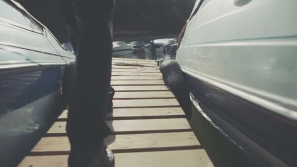 Smart businessman talking on Wooden Bridge near the moored sailing boats in a coastal city against a blue sky. — Stock Video