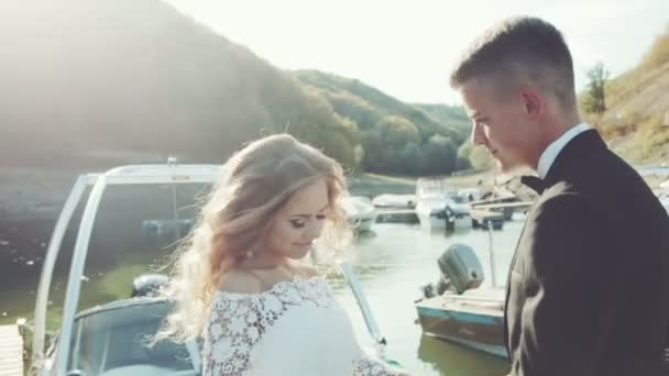 Casal feliz de casamento de mãos dadas pulando no iate no porto — Vídeo de Stock