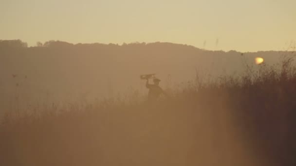 Kleine jongen met houten vliegtuig op een achtergrond-zonsondergang — Stockvideo