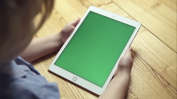 Une jeune fille tenant une tablette avec un écran vert — Video