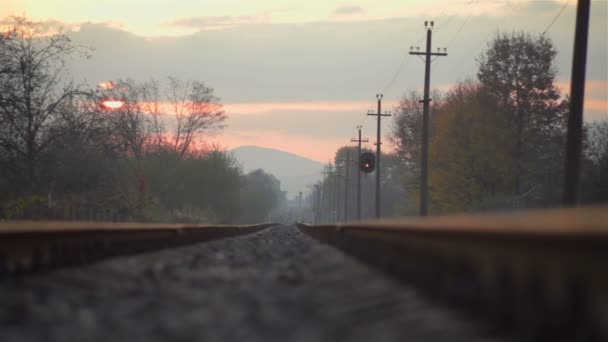 Железнодорожные пути в сельской местности с красивым пастельным закатом — стоковое видео