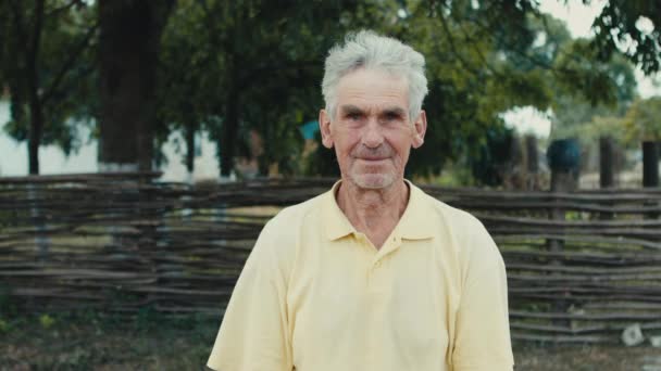 Klok gammal man på en bakgrund av träd i området bonden — Stockvideo