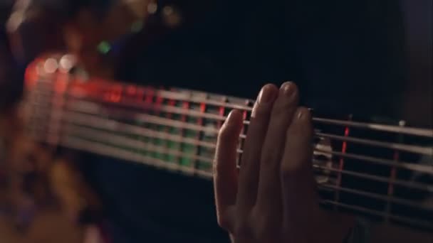 Ο άνθρωπος παίζει ηλεκτρική κιθάρα με τις ειδικές τεχνικές κάτω από το φως λάμψης — Αρχείο Βίντεο