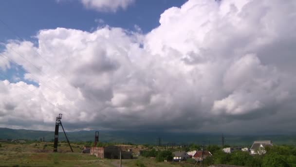 Nubes de lluvia sobre el pueblo entre montañas — Vídeos de Stock