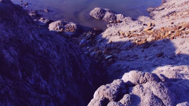 DOLLY MOTION: Precipite rocas arenosas cerca de la orilla del lago en junio. Película a color sobre el espacio . — Vídeo de stock