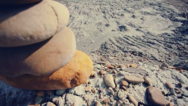 Le mouvement de la caméra à l'envers pyramide de pierres sur une colline de sable . — Video
