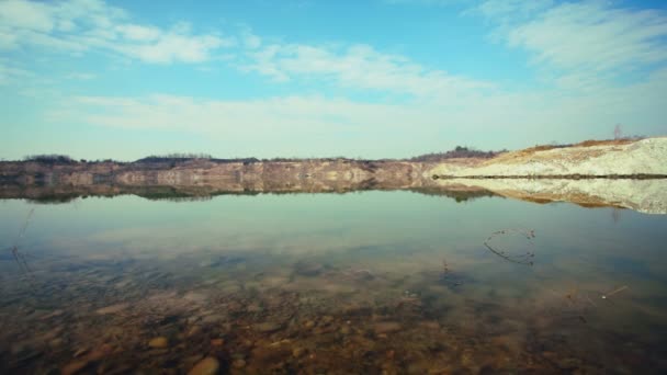 La roche arc-en-ciel se reflète dans un lac calme sous un ciel nuageux . — Video