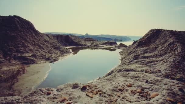 DOLLY MOTION: Un pequeño lago en el cráter. Tierra de arena roja . — Vídeo de stock