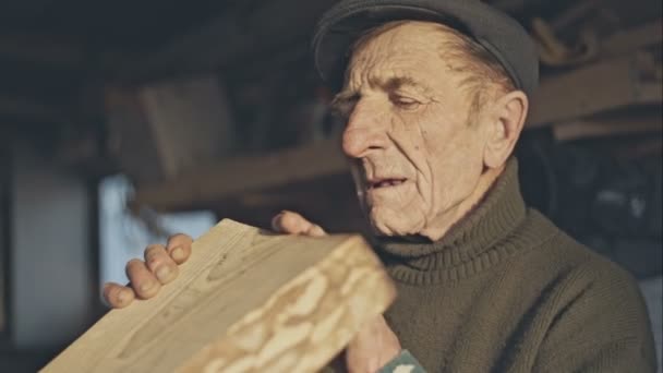 Старший тесля перевіряє шліфовану дошку в своїй майстерні — стокове відео