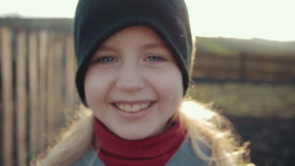 Lindo niño sonriendo en el soleado día de otoño y pone una gorra en los ojos — Vídeos de Stock