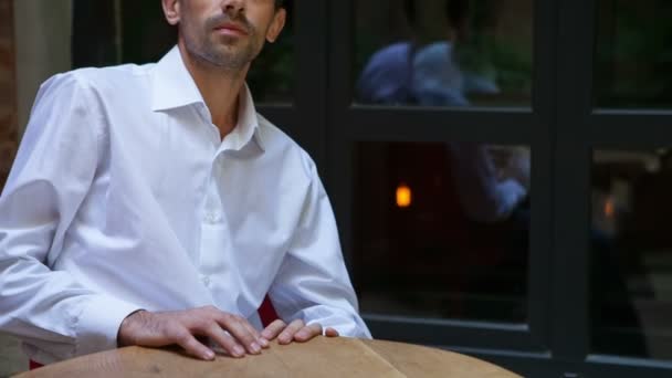 Hombre guapo y preocupado en un café a la mesa — Vídeo de stock