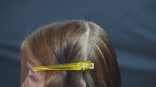 Coiffeur maître coiffant cheveux avec spray. gouttelettes d'eau voler filles cheveux sur un fond noir . — Video