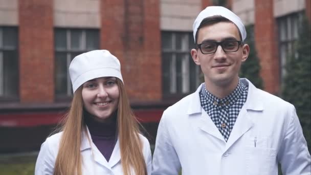 Twee van de jonge dokter op de ziekenhuis muur achtergrond — Stockvideo