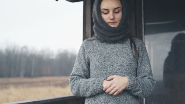 Portrét mladé smutná dívka v šátek kolem domu. Surový video záznam. — Stock video