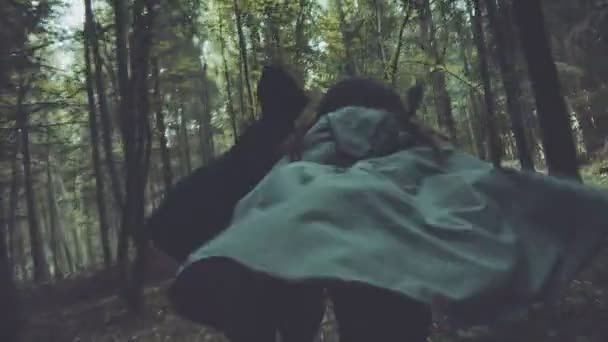 运行雾气弥漫的森林中雨衣，骚扰两未知数 — 图库视频影像