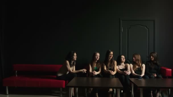 Група молодих дівчат, що розмовляють один з одним на чорному тлі — стокове відео