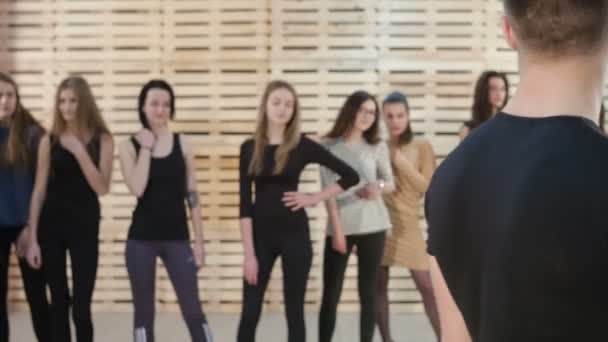 Группа девушек позирует перед обоими мужчинами — стоковое видео