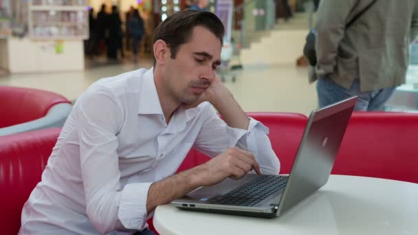 Een man vindt iets onverwacht op een laptop — Stockvideo