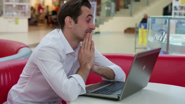 Geluk op het werk. Vertrouwen lachende zakenman in caffe aan de tafel zitten en werken op een laptop, terwijl een jonge man geniet van zijn succes — Stockvideo