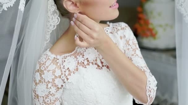 Елегантна блондинка наречена одягає сережки крупним планом, готується до весілля — стокове відео