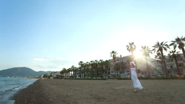 Mujer vestida de blanco y sombrero en la playa. Grabación de vídeo RAW . — Vídeos de Stock