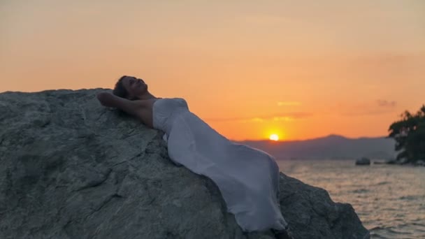 Jonge dame ontspannen in tropisch strand bij zonsondergang. Ruwe videoverslag. — Stockvideo